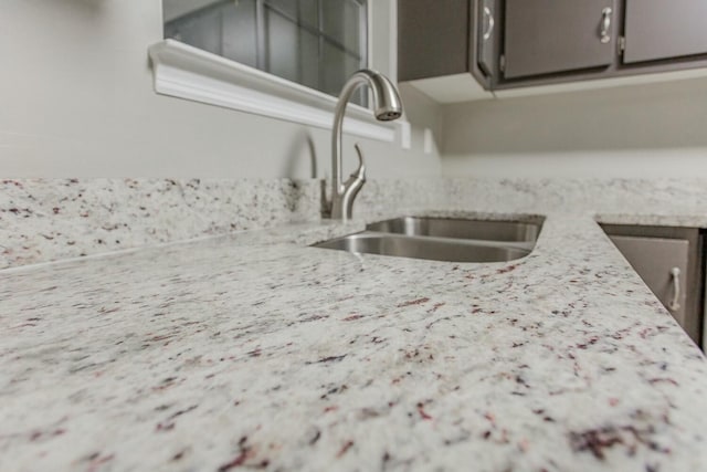 kitchen with light stone countertops and sink