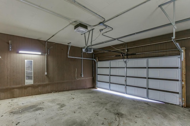 garage with wooden walls and a garage door opener