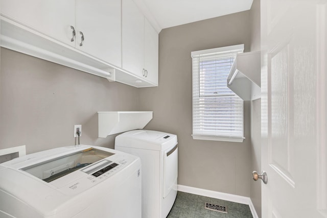 laundry room featuring cabinets and separate washer and dryer