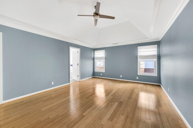 spare room featuring light wood-type flooring, a tray ceiling, ceiling fan, and ornamental molding