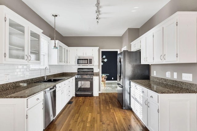 kitchen featuring decorative light fixtures, stainless steel appliances, white cabinetry, and sink