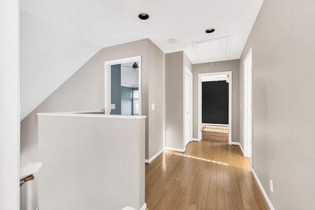 hallway featuring vaulted ceiling and light wood-type flooring