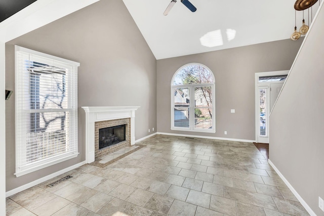 unfurnished living room with a fireplace, vaulted ceiling, and ceiling fan