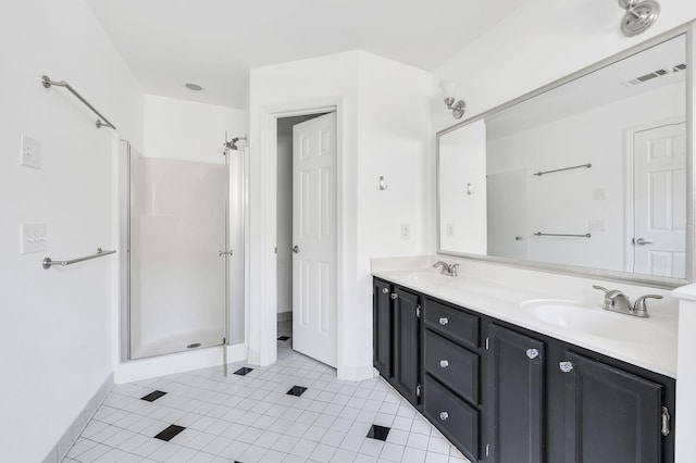 bathroom with tile patterned flooring, vanity, and a shower