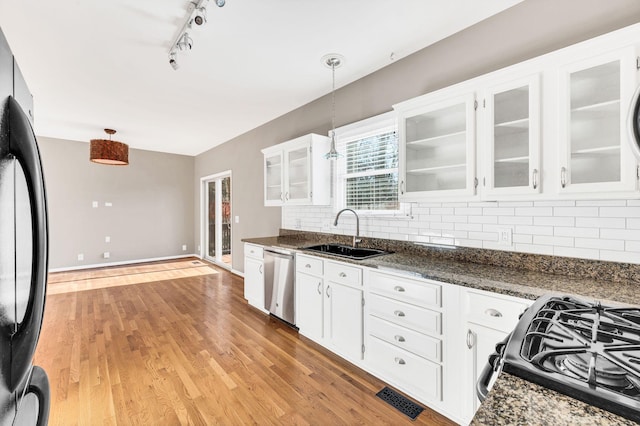 kitchen with sink, hanging light fixtures, stainless steel dishwasher, refrigerator, and white cabinets