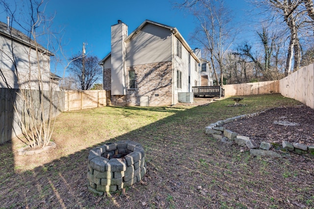 view of yard with central AC and an outdoor fire pit