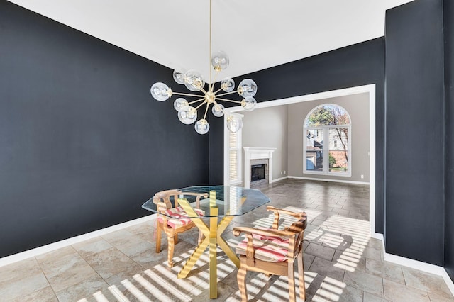 dining room featuring a high end fireplace and a chandelier