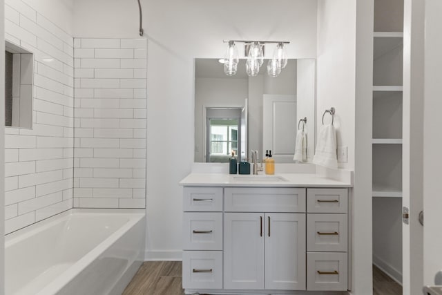 bathroom featuring hardwood / wood-style floors, vanity, and tiled shower / bath