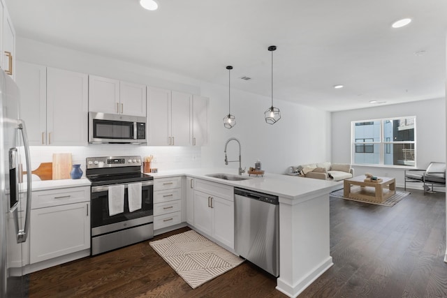 kitchen featuring white cabinets, sink, kitchen peninsula, and stainless steel appliances