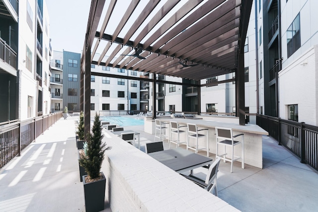 view of patio featuring a pergola, a community pool, and a bar