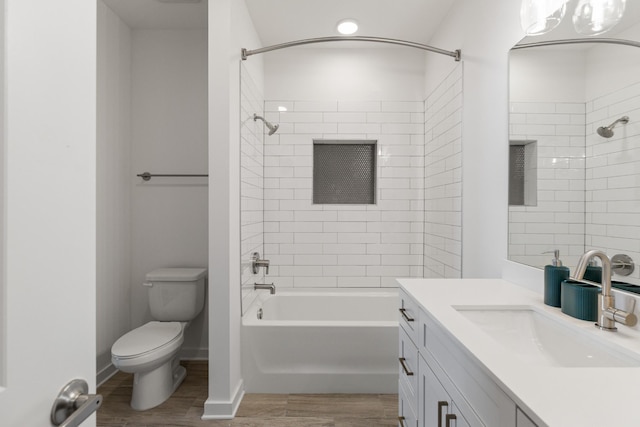 full bathroom with tiled shower / bath, hardwood / wood-style floors, vanity, and toilet