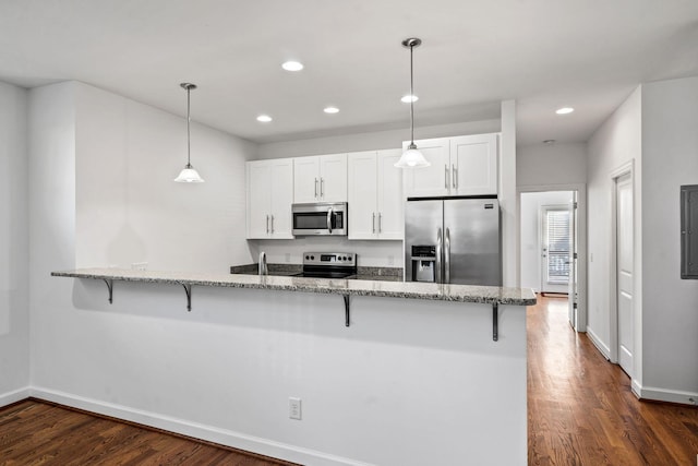 kitchen with a breakfast bar, white cabinets, light stone countertops, kitchen peninsula, and stainless steel appliances