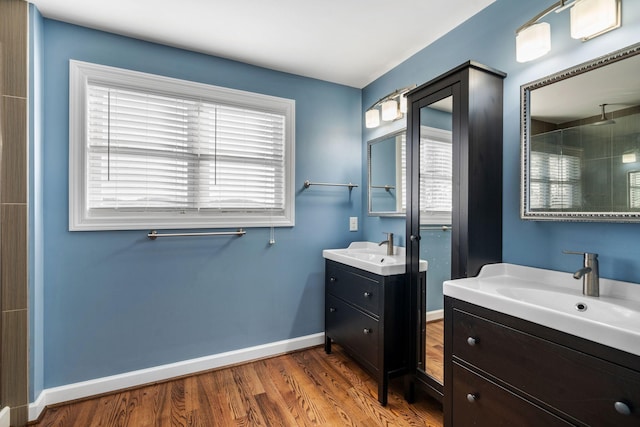 bathroom with hardwood / wood-style flooring, vanity, a tile shower, and a wealth of natural light