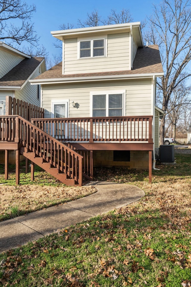 view of front of home featuring central AC unit, a wooden deck, and a front lawn