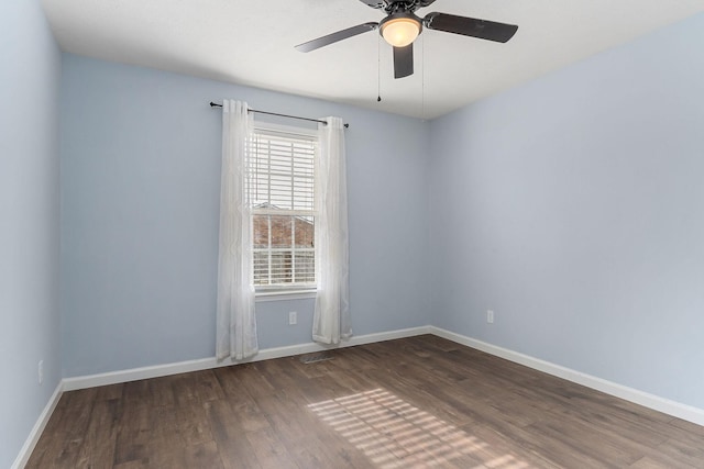 spare room featuring ceiling fan and dark wood-type flooring