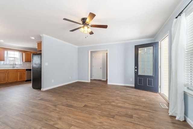 unfurnished living room featuring wood-type flooring, ceiling fan, ornamental molding, and sink