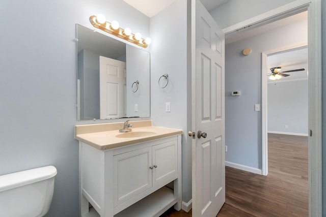 bathroom featuring ceiling fan, toilet, wood-type flooring, and vanity