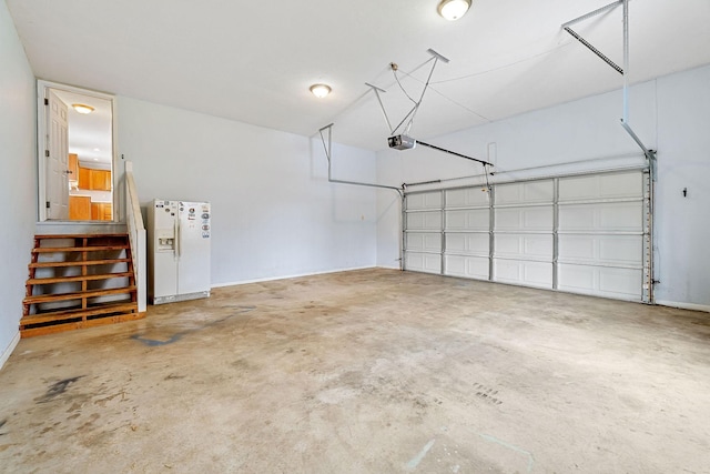 garage featuring white fridge with ice dispenser and a garage door opener