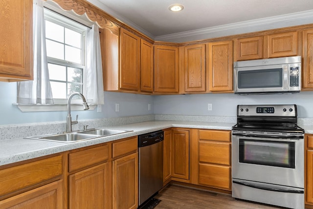 kitchen with dark wood-type flooring, crown molding, sink, light stone counters, and stainless steel appliances