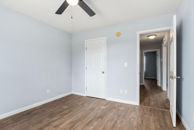 unfurnished bedroom featuring ceiling fan and dark hardwood / wood-style flooring