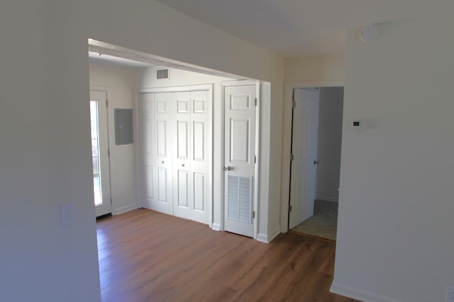 corridor featuring dark hardwood / wood-style floors and electric panel