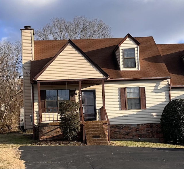 new england style home featuring a porch