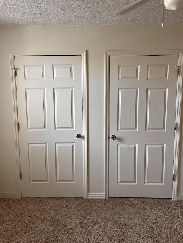 interior space with ceiling fan, carpet floors, and a textured ceiling