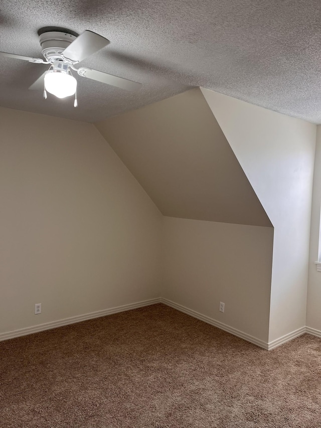 bonus room featuring ceiling fan, lofted ceiling, carpet, and a textured ceiling