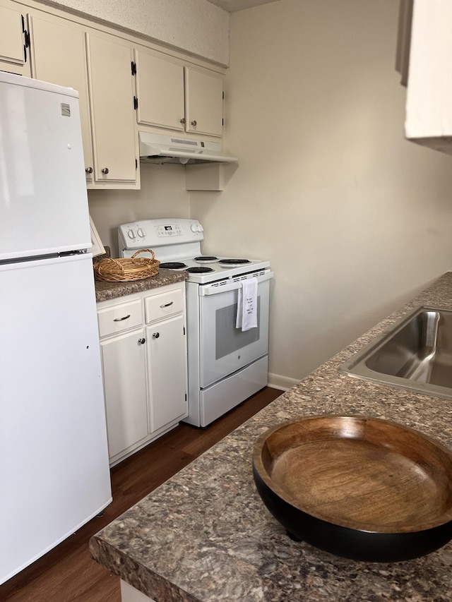 kitchen featuring sink, white appliances, and dark wood-type flooring