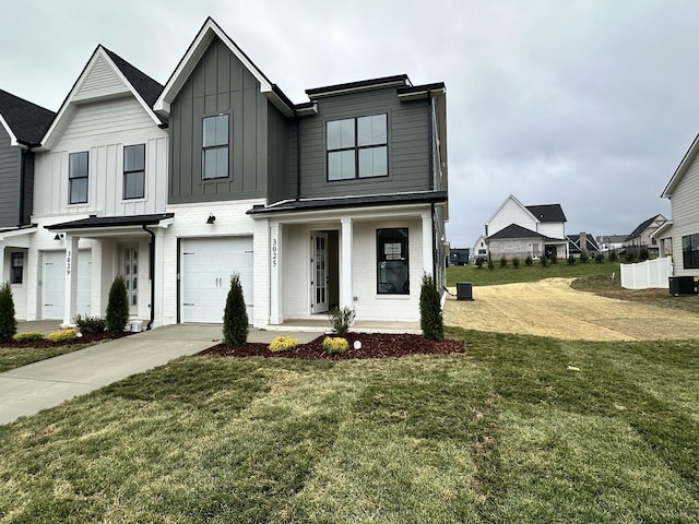 view of front of house with a porch, a garage, and a front lawn