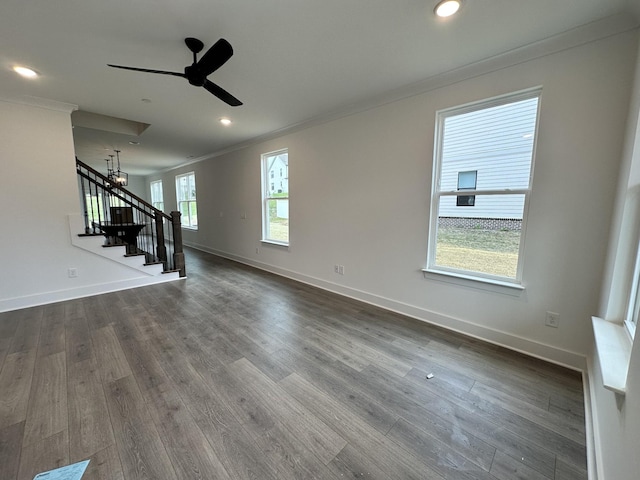 unfurnished living room featuring wood-type flooring, ceiling fan with notable chandelier, and ornamental molding