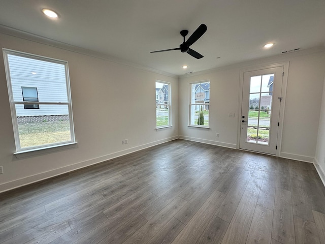 unfurnished room featuring a wealth of natural light, dark hardwood / wood-style floors, ceiling fan, and ornamental molding