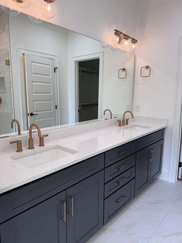 bathroom featuring double vanity, marble finish floor, and a sink