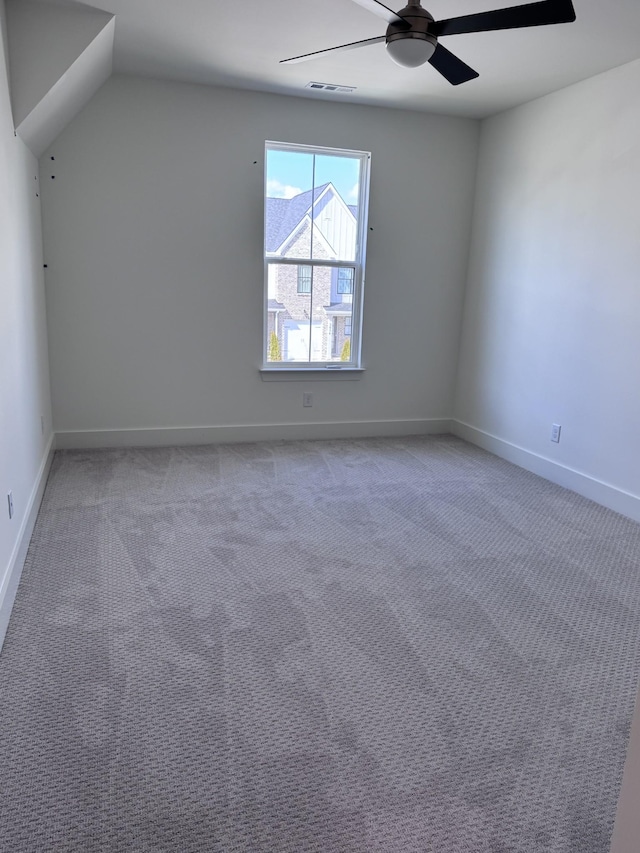 spare room with visible vents, baseboards, light colored carpet, and a ceiling fan