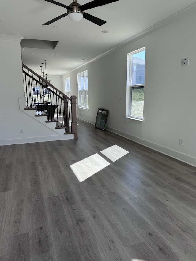 spare room featuring dark wood finished floors, stairway, ceiling fan, and baseboards