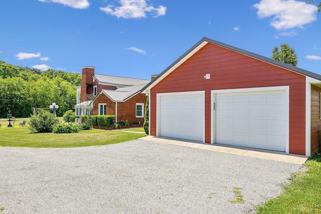 view of front facade with a garage, an outbuilding, and a front yard