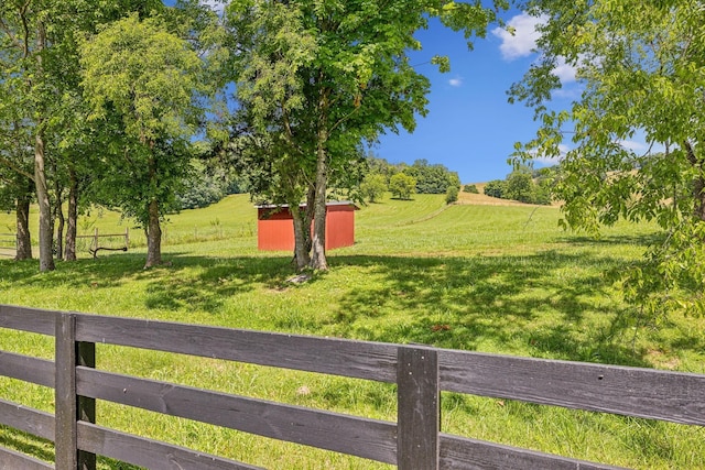 view of yard with a rural view and an outdoor structure