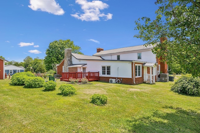 rear view of house featuring central AC unit, a lawn, and a wooden deck