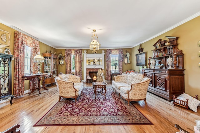 living room featuring light wood-type flooring, ornamental molding, and a brick fireplace