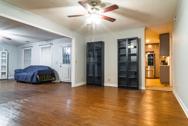 interior space with stainless steel fridge, a textured ceiling, ceiling fan, and dark wood-type flooring