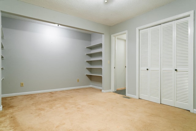 unfurnished bedroom with light carpet and a textured ceiling