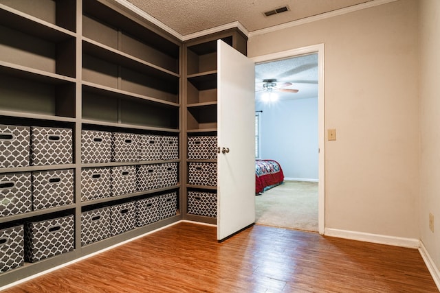 interior space featuring hardwood / wood-style floors, a textured ceiling, ceiling fan, and crown molding