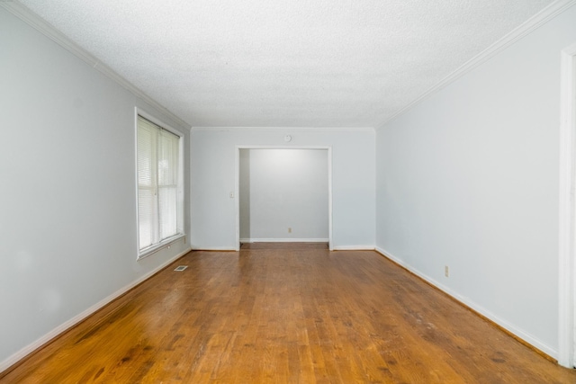 empty room with hardwood / wood-style floors and a textured ceiling