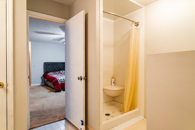 bathroom with tile patterned flooring, a textured ceiling, walk in shower, and ceiling fan