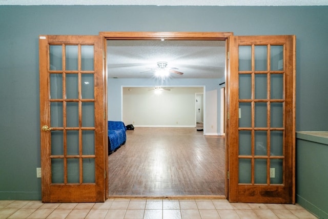 unfurnished room featuring ceiling fan, light tile patterned floors, and french doors