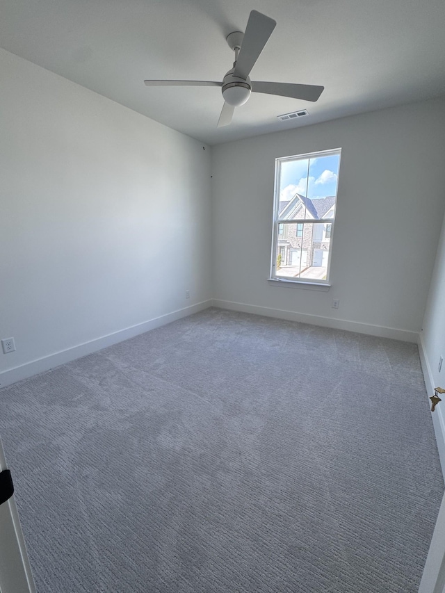 empty room featuring visible vents, baseboards, light colored carpet, and ceiling fan