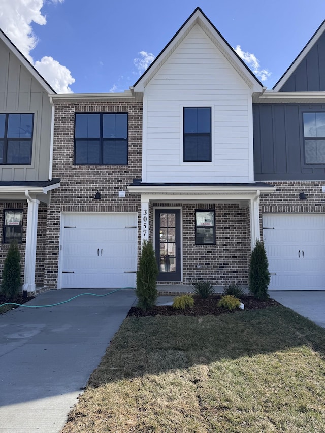 view of front facade featuring board and batten siding, concrete driveway, a front yard, a garage, and brick siding