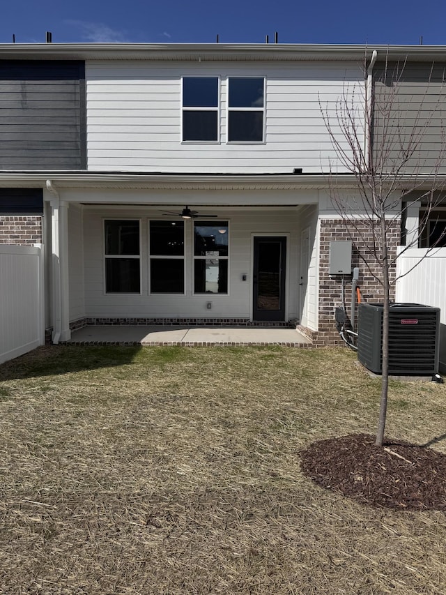 rear view of house with brick siding, fence, central AC, a ceiling fan, and a patio