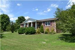 view of front of home with a sunroom and a front lawn