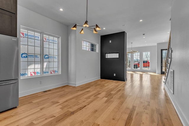 unfurnished living room featuring light wood-style flooring, visible vents, baseboards, and recessed lighting